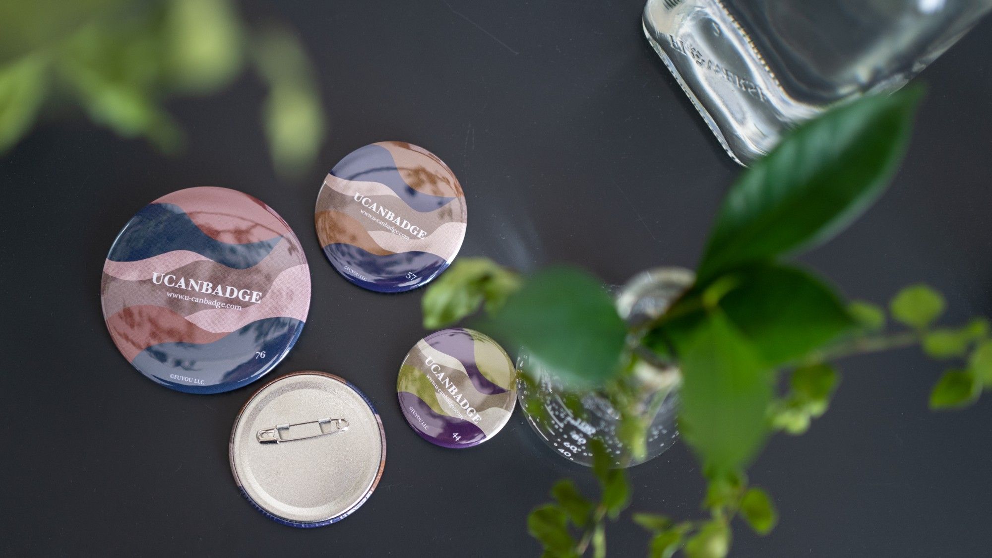 UCANBADGE の缶バッジ。大きさ違いの4つと裏面の安全ピン